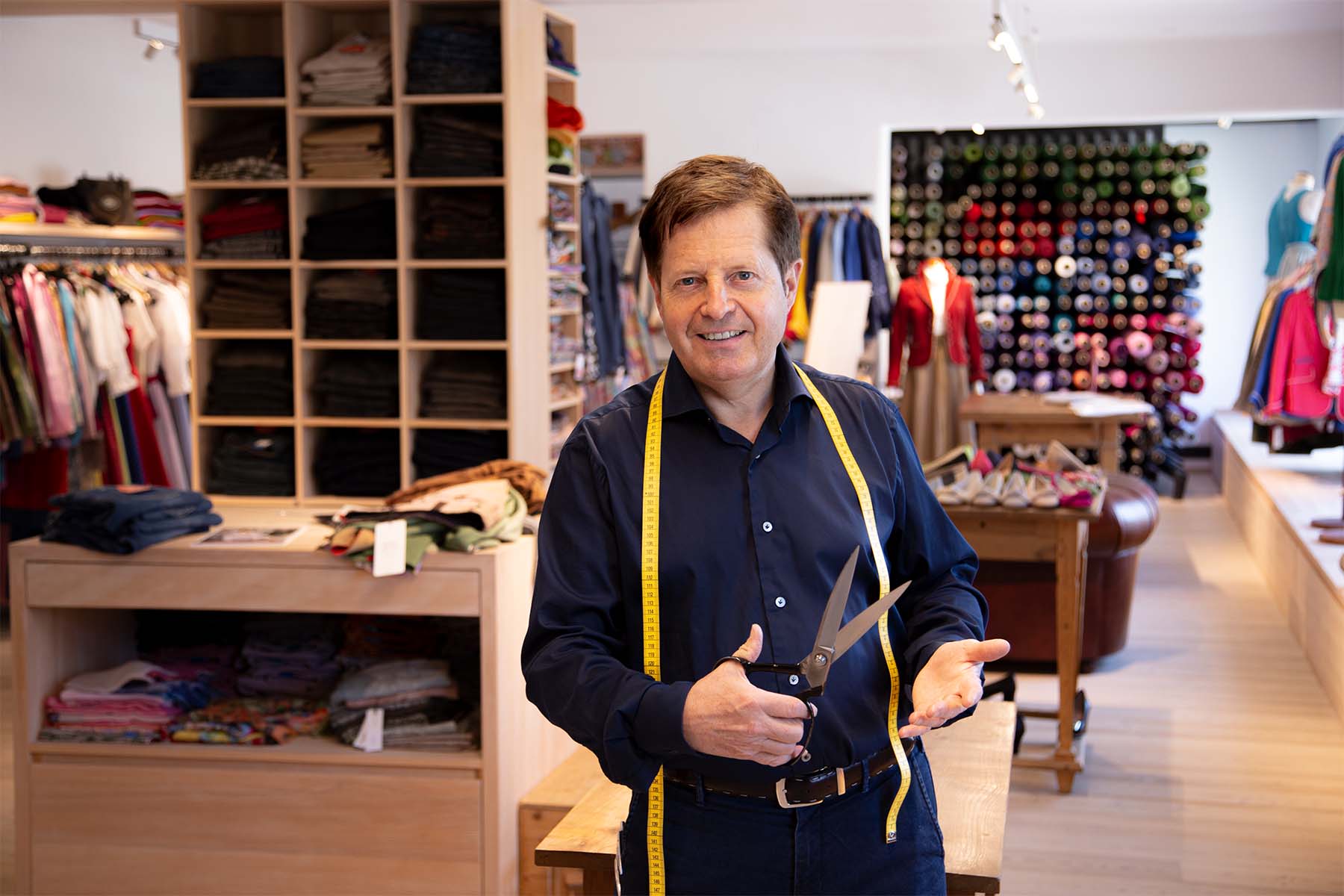 Master tailor Stefan Wimmer in his atelier with tailoring shears and a measuring tape